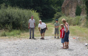Een familie speelt petanque buiten bij Feather Down La Ferme de Penquelen Huella in Bretagne, Frankrijk.