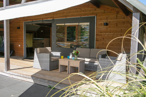 Espace terrasse à la Outdoor lodge du Holiday Park 't Rheezerwold aux Pays-Bas, mobilier en rotin.