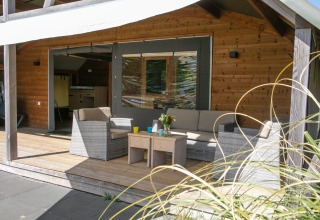 Udendørs opholdsområde ved Outdoor lodge på Holiday Park 't Rheezerwold, Holland, med kurvemøbler.
