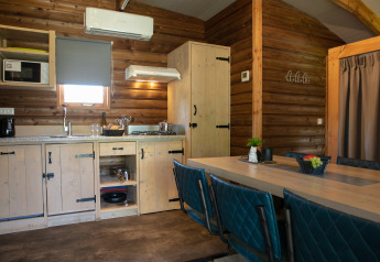 Cocina y comedor de cabaña moderna en madera en Outdoor lodge, Holiday Park 't Rheezerwold, Países Bajos.