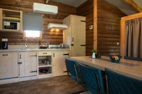 Cocina y comedor de cabaña moderna en madera en Outdoor lodge, Holiday Park 't Rheezerwold, Países Bajos.