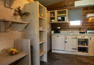 Cuisine chaleureuse à l’Outdoor Lodge du Holiday Park 't Rheezerwold aux Pays-Bas avec intérieur en bois.