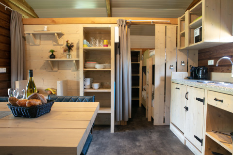 Interno della Outdoor Lodge al Holiday Park 't Rheezerwold nei Paesi Bassi con cucina e zona pranzo.