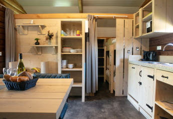 Interiør af Outdoor Lodge på Holiday Park 't Rheezerwold i Holland med spisebord og køkken.