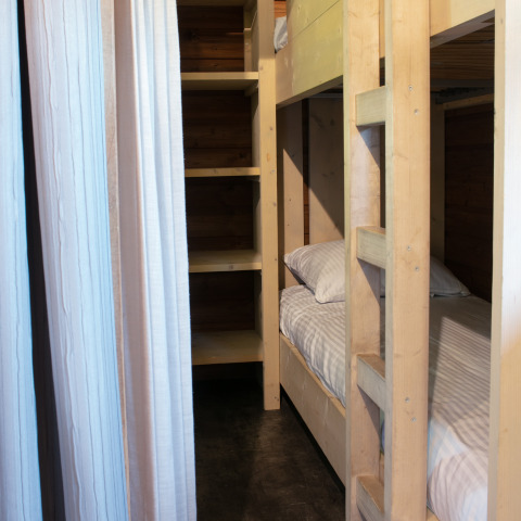 Letti a castello e scaffali in una cabina in legno all’Outdoor lodge nel Holiday Park 't Rheezerwold, Paesi Bassi.