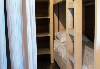 Stapelbedden en planken in een houten lodge bij Outdoor lodge op Holiday Park 't Rheezerwold, Nederland.