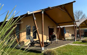 Lodge tente safari de luxe avec terrasse au Holiday Park 't Rheezerwold, Pays-Bas, sous un ciel bleu.