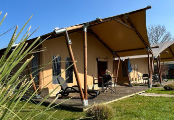 Luksuriøst safariteltsophold med terrasse på Holiday Park 't Rheezerwold i Holland under blå himmel.