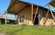 Tenda di lusso Lodge all'Holiday Park 't Rheezerwold nei Paesi Bassi, con patio e sedie all'aperto.