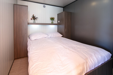 Dormitorio dentro de Luxury Tent Lodge en Holiday Park 't Rheezerwold en los Países Bajos con cama doble.