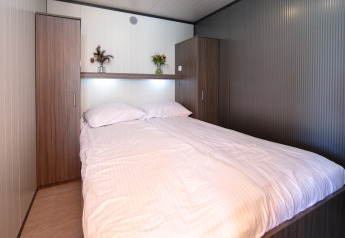 Schlafzimmer im Luxury Tent Lodge im Holiday Park 't Rheezerwold in den Niederlanden mit Doppelbett.