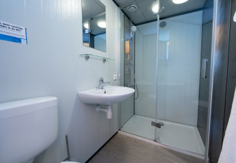 Baño con ducha, lavabo, espejo y wc en Luxury Tent Lodge en Holiday Park 't Rheezerwold, Países Bajos.