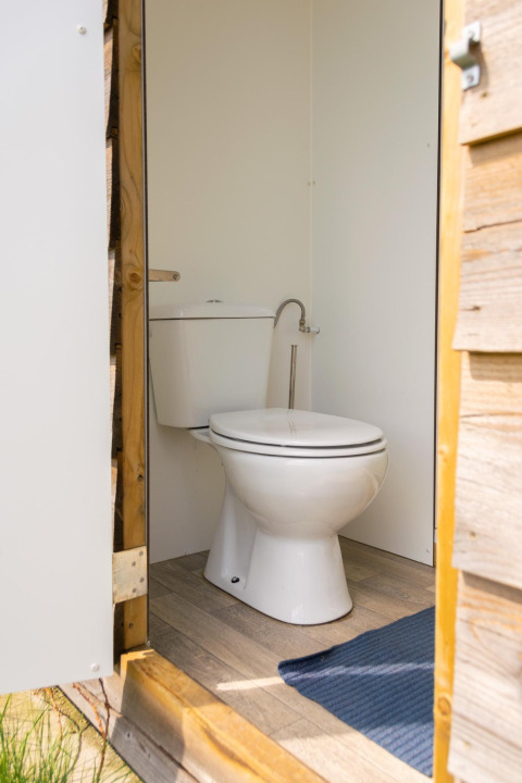 Eine moderne Toilette in einem Safarizelt auf Camping De Betteld in den Niederlanden, von außen gesehen.