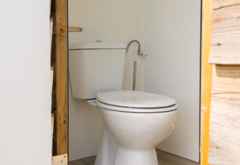 Un moderno WC all'interno di una tenda safari al Camping De Betteld nei Paesi Bassi, visto dalla porta aperta.