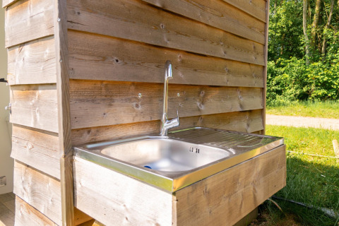 Außenwaschbecken an einem Safarizelt beim Camping De Betteld in den Niederlanden, umgeben von Natur.