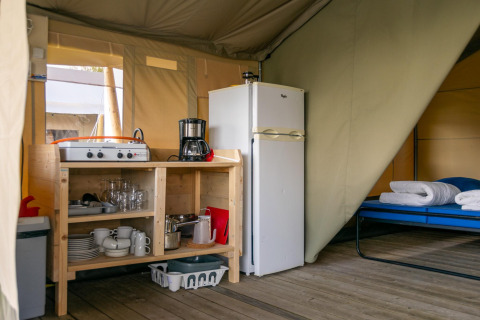 Innenansicht eines Safari-Zeltes auf dem Camping De Betteld in den Niederlanden mit Küche und Bett.