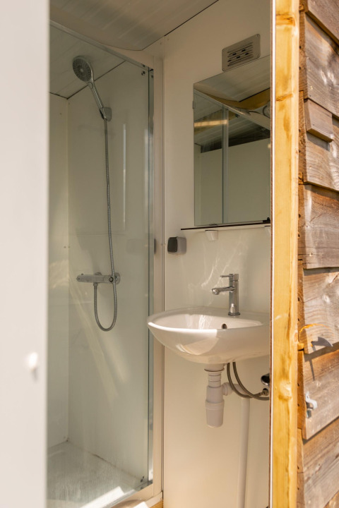 Bagno con doccia e lavandino in una tenda safari al Camping De Betteld nei Paesi Bassi, vista interna.