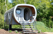 Moderne, buisvormige tiny house Anthropod met trap bij Holiday Park 't Rheezerwold in Nederland.