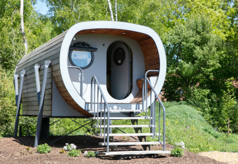 Casa diminuta moderna de forma tubular llamada Anthropod con escalera en Holiday Park 't Rheezerwold, Países Bajos.