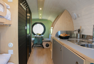 Interior de una casa diminuta llamada Anthropod en Holiday Park 't Rheezerwold, Países Bajos, con cocina moderna.