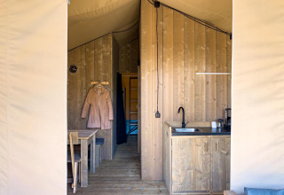 Interior view of a luxury safari tent with private bathroom and kitchen at Camping De Betteld in the Netherlands.