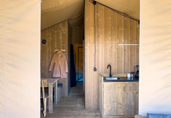 Interior view of a luxury safari tent with private bathroom and kitchen at Camping De Betteld in the Netherlands.