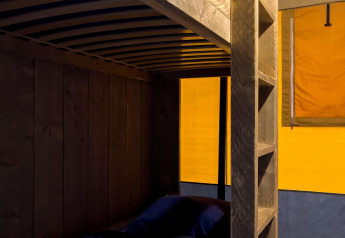 Interieur van een luxe safaritent met stapelbed bij Camping De Betteld in Nederland, warm verlicht.