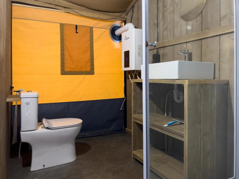 Bagno moderno in una tenda safari di lusso con wc e lavabo al Camping De Betteld nei Paesi Bassi.