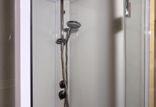 Moderne douche in luxueuze safaritent met regendouche bij Camping De Betteld, Nederland, vanuit de ingang.