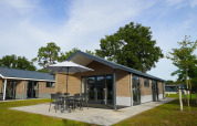 Moderne lodge ved Velthorst på Zilverstrand i Belgien, med terrasse, spisebord og parasol udenfor.