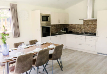 Salle à manger et cuisine modernes au lodge Velthorst, Zilverstrand, Belgique, dressées pour six personnes.