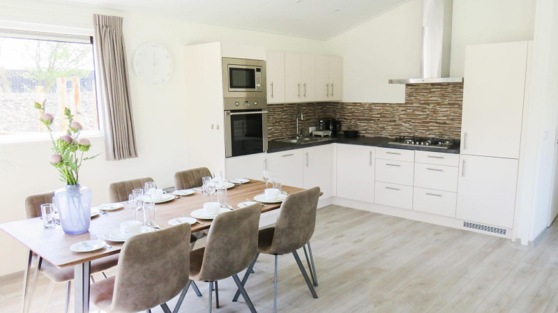 Modern dining and kitchen area at Velthorst lodge, Zilverstrand, Belgium, set for six guests.