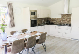 Modernes Ess- und Küchenbereich in der Velthorst-Lodge, Zilverstrand, Belgien, für sechs Personen.