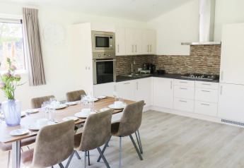 Moderne eet- en keukenruimte in Velthorst-lodge, Zilverstrand, België, gedekt voor zes personen.