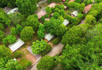Vue aérienne des tentes safari Villatent Nomad entourées d'arbres au Camping La Clémentine en France.