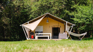 Safari-Zelt Villatent Wood auf Camping Au Clos de La Chaume in Frankreich mit Hängematte und Terrasse vorne.