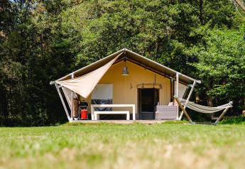 Safaritent Villatent Wood op Camping Au Clos de La Chaume in Frankrijk met hangmat en zithoek buiten.
