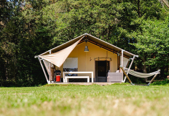 Safari-Zelt Villatent Wood auf Camping Au Clos de La Chaume in Frankreich mit Hängematte und Terrasse vorne.