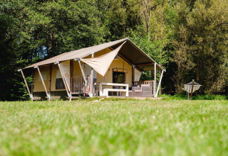 Tienda safari Villatent Wood en Camping Au Clos de La Chaume, Francia, rodeada de naturaleza verde y tranquila.