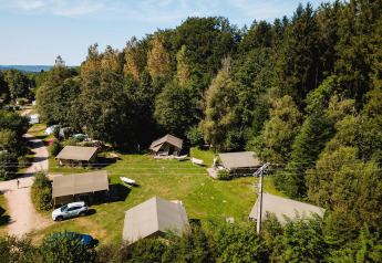 Vue aérienne des tentes safari Villatent Wood au Camping Au Clos de La Chaume, entourées de forêt en France.