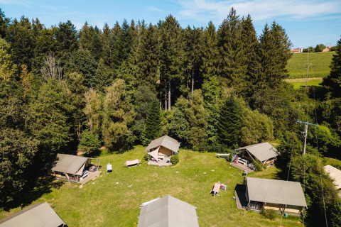 Vue aérienne des tentes safari Villatent Wood au Camping Au Clos de La Chaume, entourées de forêt en France.