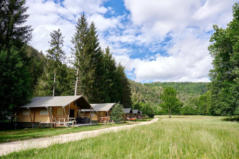 Safari-Zelte bei Camping de Vaubarlet in Frankreich, eingebettet in grüne Landschaft und Wald.