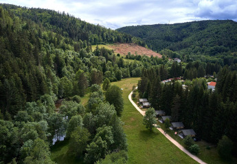 Vue aérienne d’une vallée verdoyante avec tentes safari à Villatent Wood, Camping de Vaubarlet en France.