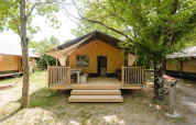 Villatent Outback en Medrose Camping, Francia, con una tienda tipo lodge acogedora y terraza entre árboles.