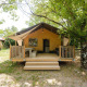 Villatent Outback at Medrose Camping in France, showcasing a cozy lodge-style tent and veranda among trees.