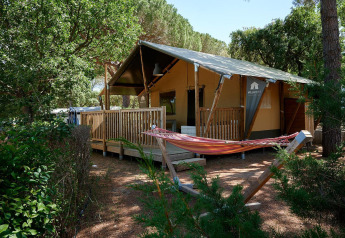 Safari tent Villatent Outback op Camping Leï Suves in Frankrijk met houten terras en hangmat tussen bomen.
