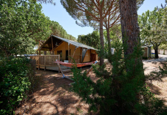 Safari-Zelt Villatent Outback auf Camping Leï Suves in Frankreich, umgeben von Bäumen und Hängematte.
