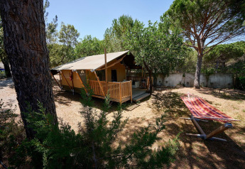 Safari-Zelt Villatent Outback auf Camping Leï Suves in Frankreich mit Bäumen und Hängematte im Garten.
