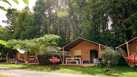 Safaritent Villatent Wood op Camping Domaine du Logis in Frankrijk, tussen groene bomen en natuur.