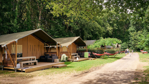 Safari tents at Villatent Wood, Camping Domaine du Logis in France, surrounded by greenery and relaxation.